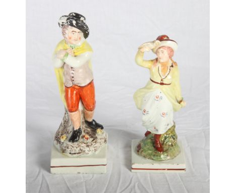 An early 19th Century Staffordshire figure of a man with a cloak, 8" high, a similar figure of a girl with a dove, 7" high (r