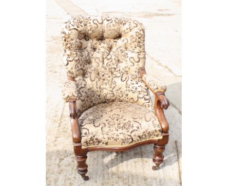 A Victorian mahogany framed open armchair, button upholstered in a brown and gold embossed velour, scroll arm terminals, on t