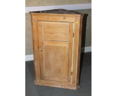 A 19th Century pine wall hung corner cabinet enclosed twin panel doors