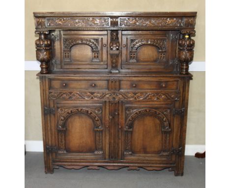An Elizabethan design oak court cupboard with canopy top, on cup and cover supports, fitted two drawers and cupboard to base 