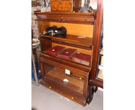 A Gunn Furniture Co oak three-stage sectional bookcase with up and over glazed panel doors, 34" wide