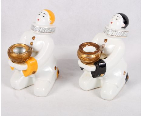 A French porcelain inkwell and pen holder in the form of a kneeling Pierrot and a similar candlestick