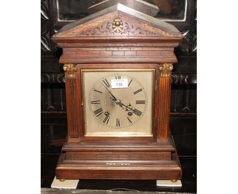 An early 20th Century oak cased mantel clock with silvered dial, 17" high