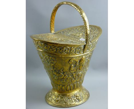 A repousse brass twin lidded helmet shaped coal bucket, 53 x 44 cms