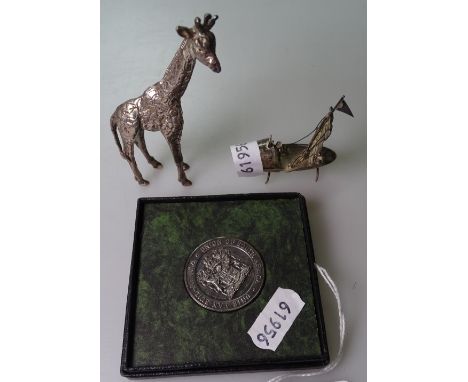 A cast silver giraffe, height 8cm, and a small sterling silver model of a junk, height 6cm, and a silver Union of South Afric