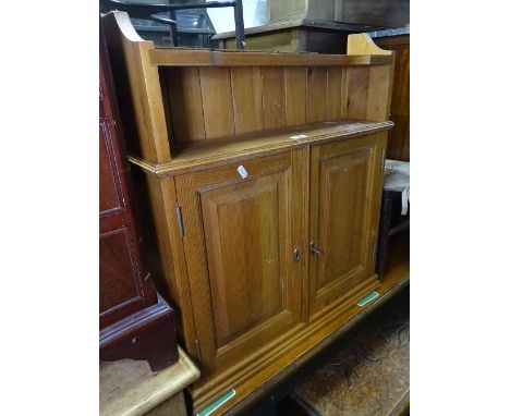 A hanging pine cabinet, with 2 panelled doors and shelf under, W64cm 