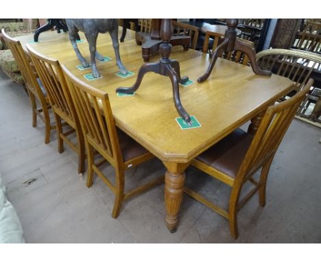 A late Victorian oak wind-out dining table, of cantered corner form, raised on turned baluster legs, together with 3 spare le