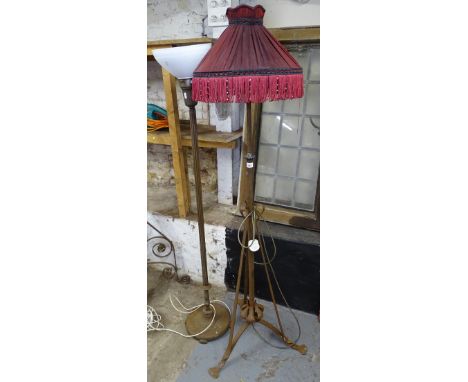 An Art Nouveau iron standard lamp, converted to electricity, with tasseled shade, and an early 20th century cast-iron standar