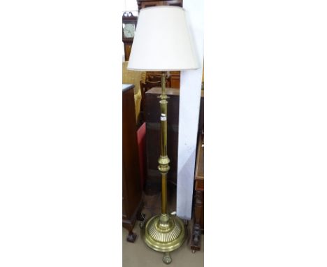A brass standard lamp on lion paw feet, and shade 