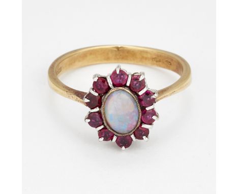 AN 18 CARAT GOLD OPAL AND RUBY CLUSTER RING,&nbsp;an oval opal within a border of round-cut rubies. Hallmarked import London 