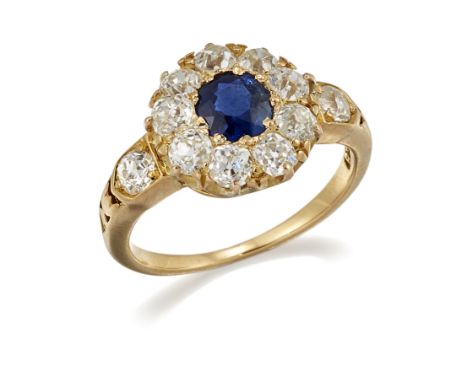 A SAPPHIRE AND DIAMOND CLUSTER RING, a round-cut sapphire within a border of old-cut diamonds, to diamond set and carved shou