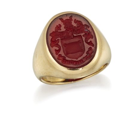 AN 18 CARAT GOLD CARNELIAN INTAGLIO SIGNET RING,&nbsp;an oval-cut carnelian engraved with a crest, to a tapering shank. Hallm