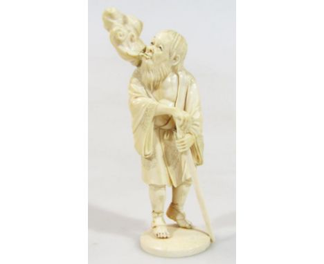 A Japanese Meiji period ivory figure of a gentleman, in flowing floral robes holding staff, on a circular base, unmarked, 15c