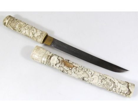 A 19thC Japanese bone cased tanto dagger, with heavily carved scabbard and handle raised with figures, with a floral banding 