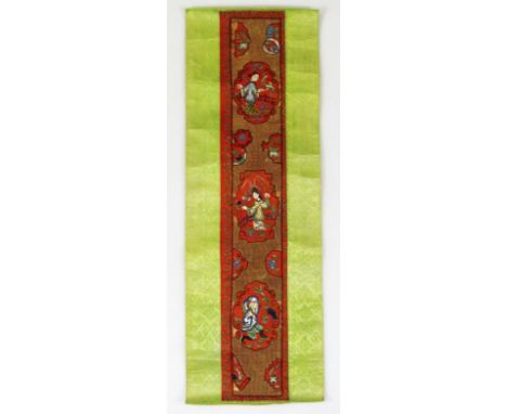 A Chinese silk work embroidery, possibly a shoulder epaulette decorated with panels of figures and trees on a gilt ground rai