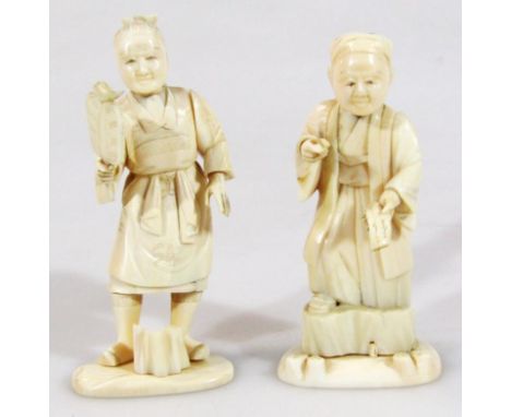 A Japanese Meiji period ivory figure of a gentleman, in flowing robes holding parchment, on shaped base, red mark beneath, pr