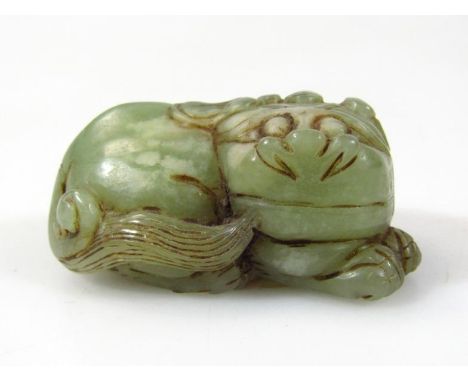 A polished green jade figure of a lion, recumbent position with smiling face, 6cm wide, unmarked with paperwork stating ... T