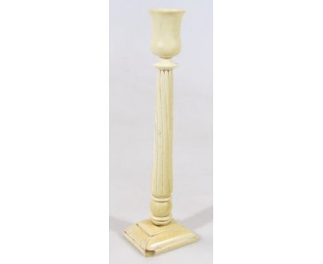 A late 19thC ivory candlestick, with urn dish holder on tapering circular fluted stem and orb and stepped base, 35cm high. (A