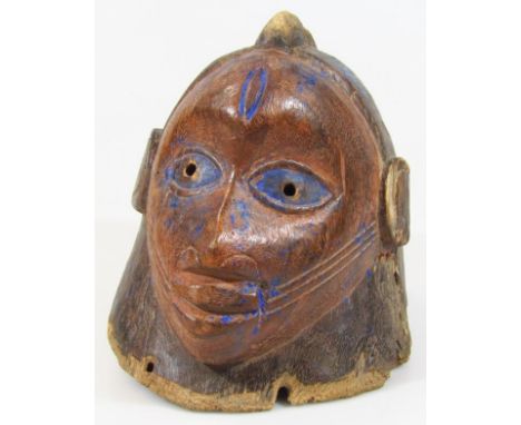 A carved tribal Yuraba wooden helmet mask, with traces of blue paint to the eyes and head with shaped features of elaborate f