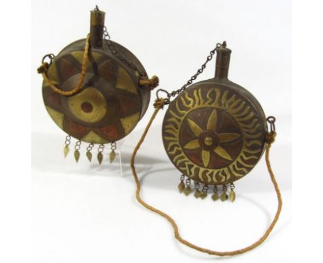 A Middle Eastern Arabic brass and copper powder flask, of circular outline with a sun motif and cylindrical top with stopper 