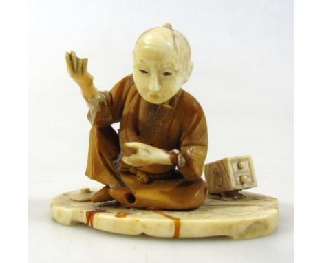 A 19thC Japanese ivory figure group, of a gentleman in interior setting aside small chest of drawers, with a shaped base on c