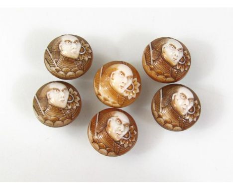 A set of six Japanese glass buttons, each formed with samurai figure heads of circular outline, 2cm diameter, probably late M