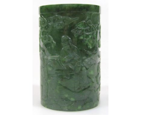 A 20thC Chinese spinach jade brush pot, of cylindrical outline, carved and polished with various scholars, flower heads, etc.