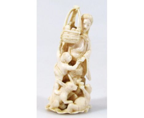 An early 20thC ivory figure of a lady in flowing robes, aside child, rabbit and monkey, holding basket on shaped leaf foot, r