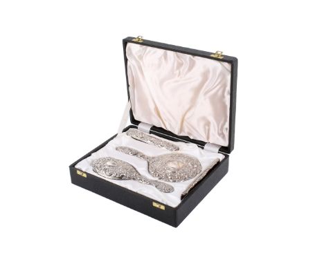 A four-piece silver mounted dressing table set. Including a hand mirror, two brushes and a comb. Hallmarks for W I Broadway &