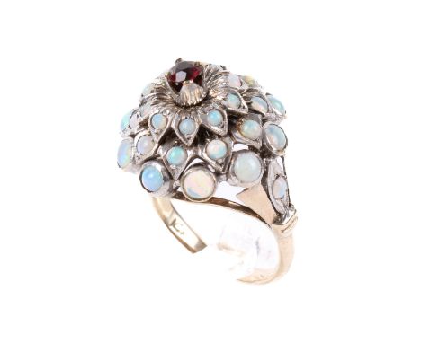  A gold and opal cluster ring. Set with three tiers of graduated opals with a brilliant cut ruby to the centre. The shank mar