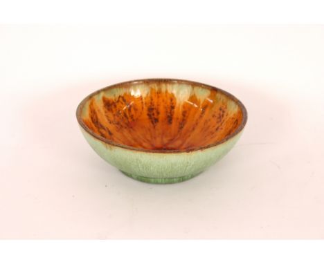 An unmarked Studio pottery bowl, probably Ruskin, having sunflower decoration, 18.5cm dia.