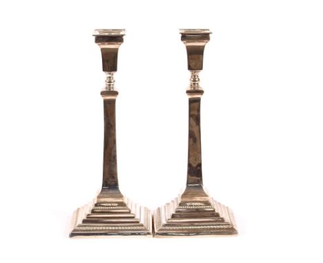 A pair of mid 20th Century silver candlesticks, raised on beaded stepped bases, London 1957, 30cm high, 24ozs