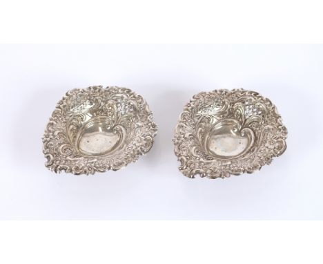 A pair of silver heart shaped pin dishes, with floral embossed decoration, Birmingham 1912