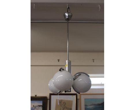 A chrome pendant light fitting, fitted three opaque glass globular shades