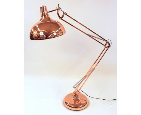 A large coppered angle poise floor lamp