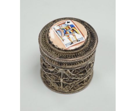 A continental filigree white metal and enamelled cylindrical pill box, the cover enamelled with a picture playing card, heigh