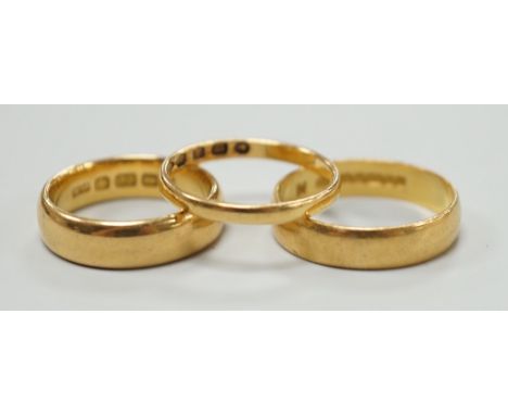 A thin Victorian 22ct gold wedding band, London, 1875, size K/L and two later 22ct gold wedding bands, including Edwardian (1