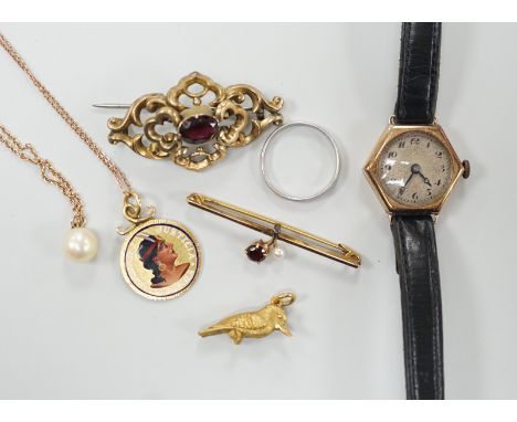 A platinum wedding band, 2.3 grams, a 9ct gold, garnet and seed pearl set bar brooch, a bird charm, a yellow metal and enamel