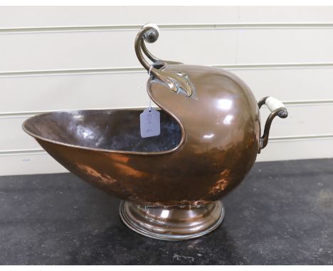 A helmet shaped copper coal scuttle, with ceramic handles, 52cms wide