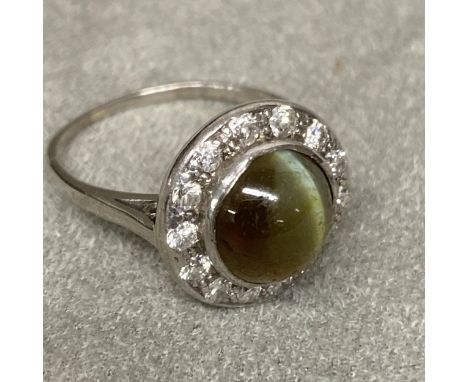 An Art Deco Chrysoberyl Cats Eye, and diamond ring, unmarked white metal, (platinum), ventral cabochon cut circular chrysober