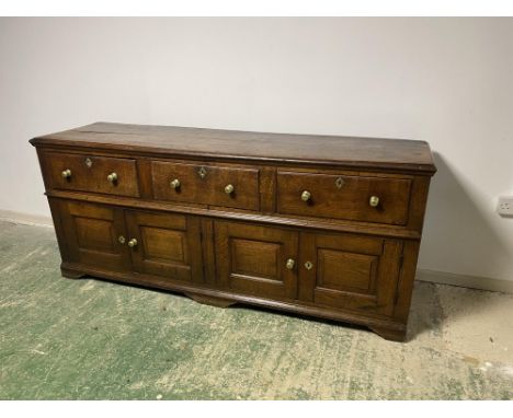 &nbsp;A good heavy oak side board, with 3 drawers, above 2 cupboard doors opening to reveal a curved fitted shelf to each sid