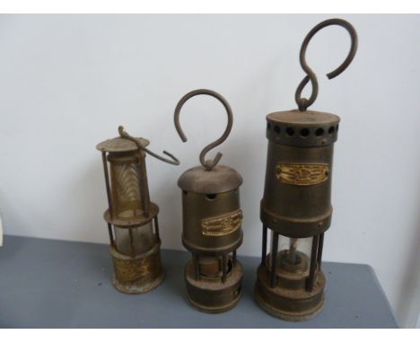 A brass miners lamp by E. Thomas & Williams, 16cm, with another, together with another miners lamp