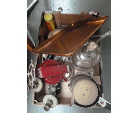 A mixed box of items including a copper tray, distillery bottle, a vintage iron, an AA car badge, a circular barometer, and a