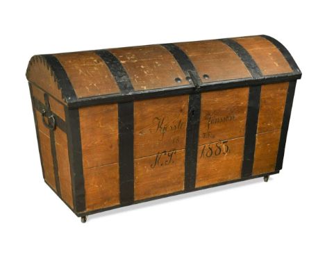 A Victorian oak dome topped steamer trunk, the trunk and hinged lid metal bound with side carrying handles raised on castors,