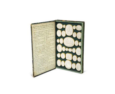 A set of Grand Tour plaster intaglios, depicting works by Canova, early 19th century, in a faux book with marbled covering an