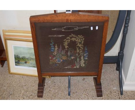 An oak framed needlework fire screen