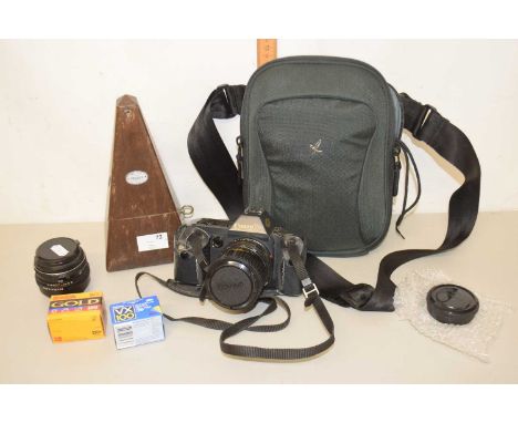 A vintage metronome together with a Cannon T70 camera with lenses