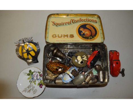 A squirrel confectionary tin containing mixed items to include a small Schuco wind up model car, white metal parasol, vintage