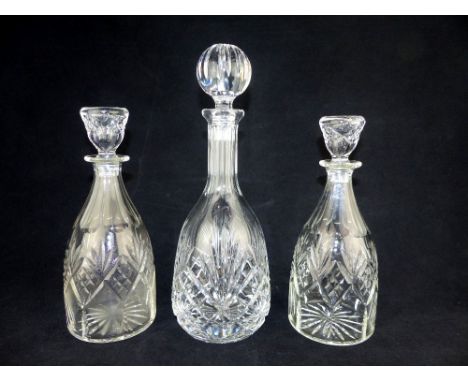 A pair of early 20th C cut glass mallet form decanters and stoppers, sold together with another cut glass decanter and stoppe