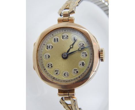 A vintage ladies 9ct gold wristwatch, the yellow metal dial with Arabic numerals, fitted expanding strap. 